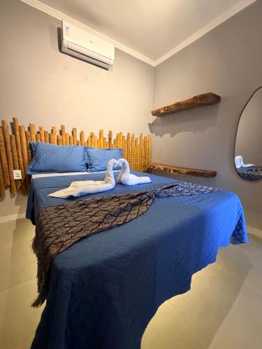 a bedroom with a blue bed with swans on it at Bangalô Miramar Maragogi in Maragogi