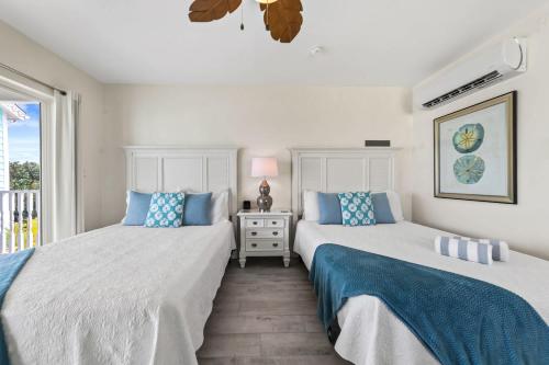 zwei Betten in einem Zimmer mit Fenster in der Unterkunft The Sand Dollar at Cottages in Sand Bluff