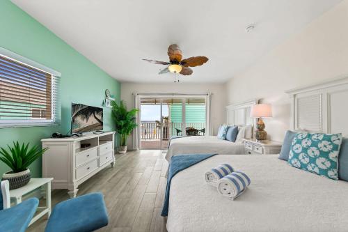 a bedroom with two beds and a ceiling fan at The Sand Dollar at Cottages in Sand Bluff