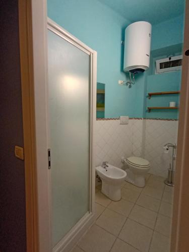 um banheiro com vaso sanitário e uma porta de vidro em La Casetta em Ancona