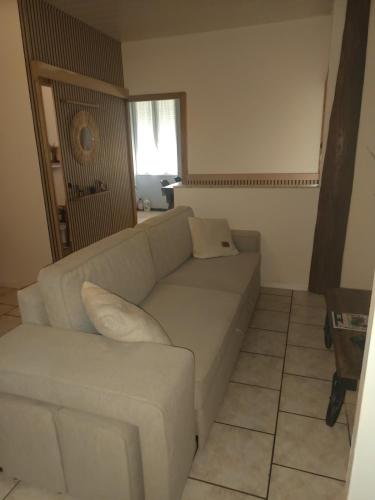 a living room with a white couch and a window at Soso et Pat in Fourchambault