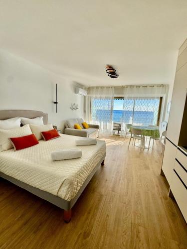 a bedroom with a bed and a living room at Casa Sud Menton vue mer exceptionnelle terrasse parking inclus climatisation in Menton