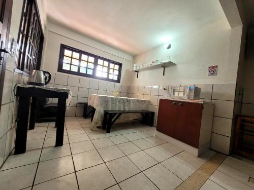 cocina con mesa en el centro de una habitación en Pousada do Boto, en Garopaba