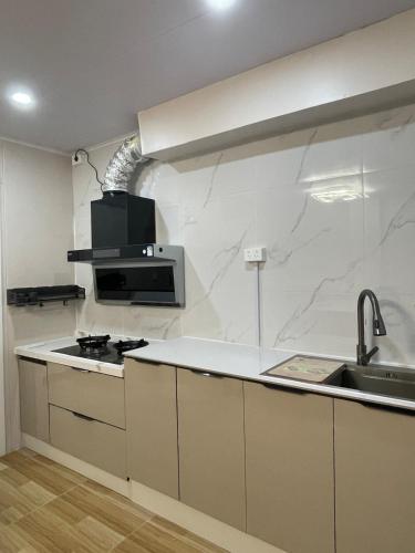 a kitchen with white marble walls and a sink at Priscilla Apartment in Nadi