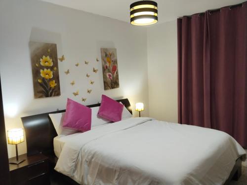 a bedroom with a large white bed with purple pillows at El apartamento de Isa tercero sin ascensor in Alcalá de Guadaira