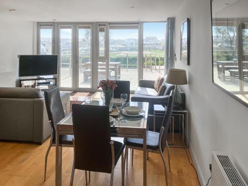 a living room with a dining room table with chairs at 12 Zinc in Newquay