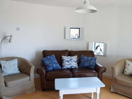 a living room with a couch and two chairs at Sea Drift in West Bay