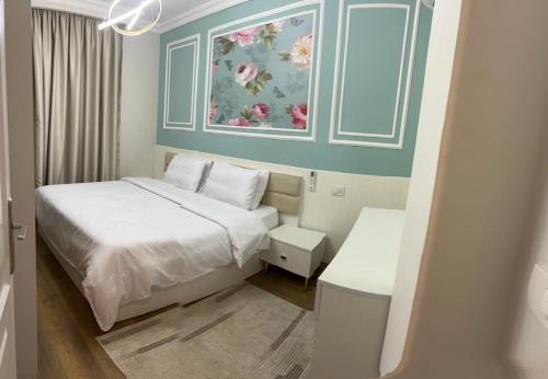 a bedroom with a bed and a painting on the wall at Dar Residence - Madinaty B12 - U2 - 2 BR - New Cairo in Madinaty
