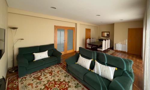 a living room with a green couch and a table at Casa do Pereiro in Vieira do Minho