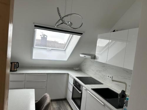 una cucina bianca con finestra e lavandino di Ferienwohnung Steinberg a Dietzenbach