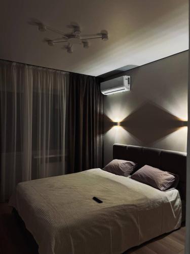 una camera da letto con un letto bianco e luci di Затишна квартира в центрі! a Černihiv