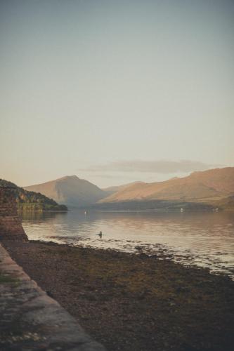 a body of water with mountains in the background at NICHT' Apartments Inveraray Town Centre in Inveraray