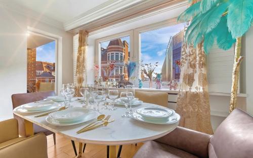 a dining room with a table and a window at PANORAMIC Apartment with Terrace on HARRODS in London