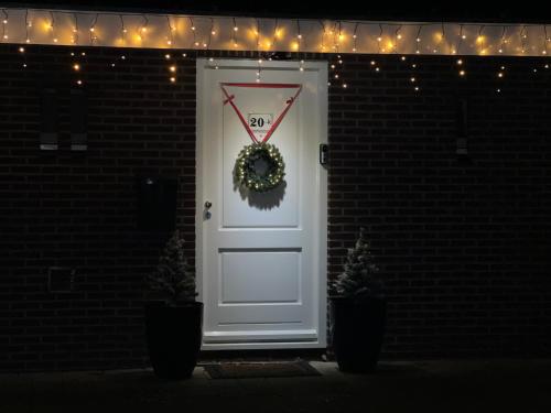a white door with a wreath on it at Vakantiehuisje Ommen in Ommen