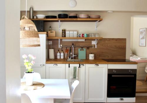 a kitchen with white cabinets and a table with flowers at Villa Linnea in Hanko