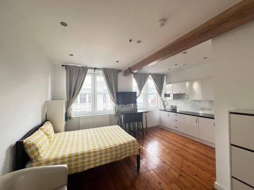 a living room with a bed and a kitchen at Heart of Notts, Spacious Studio, Great City Views in Nottingham