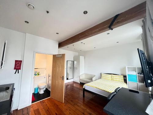 a living room with a couch and a table at Heart of Notts, Spacious Studio, Great City Views in Nottingham