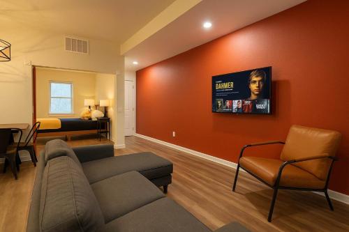 a living room with a couch and a tv on a wall at Soulard King Loft near Anheuser-Busch Brewery in Saint Louis