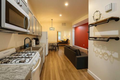 a kitchen with a stove and a living room at Soulard King Loft near Anheuser-Busch Brewery in Soulard