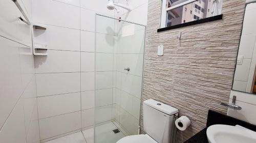 een witte badkamer met toilet en douche bij Atalaia mar in Aracaju