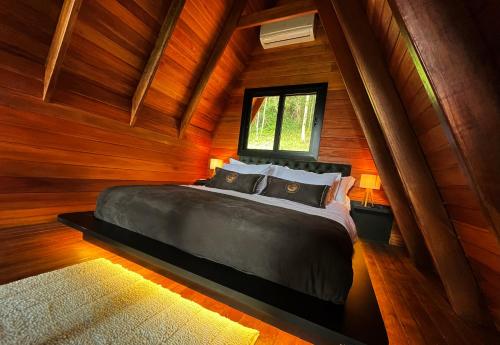 a bedroom with a bed in a wooden room at Cabana Canto do Bugio in Gramado