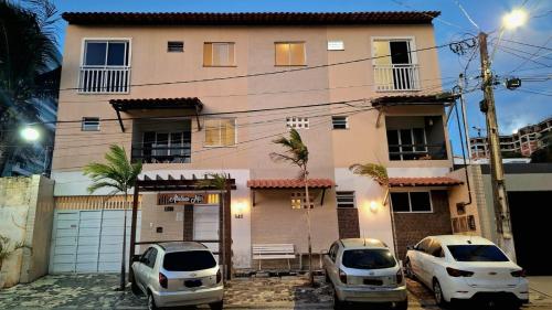 twee auto's geparkeerd voor een huis bij Atalaia mar in Aracaju