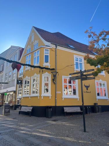 a yellow building on the side of a street at Niollo Hotels in Aabenraa