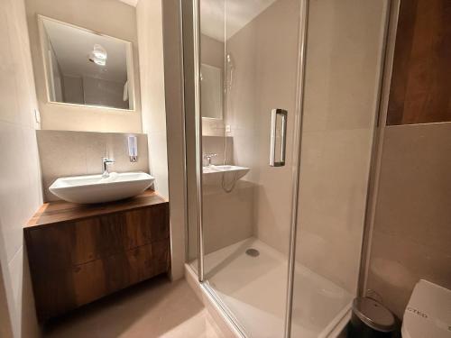a bathroom with a sink and a shower at Devana Premium Apartments by CHORS in Nivy