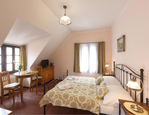 um quarto com uma cama, uma mesa e cadeiras em Penzion Na 15. Poledníku em Jindřichŭv Hradec