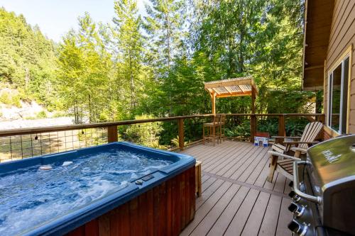 a hot tub on the deck of a house at PNW River Cabin in Darrington