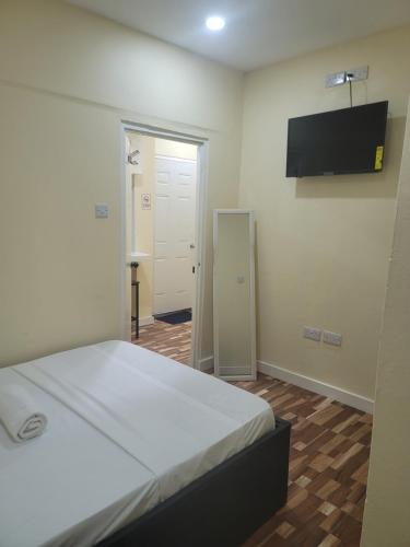 a bedroom with a bed and a flat screen tv at Midtown in Saint Georgeʼs