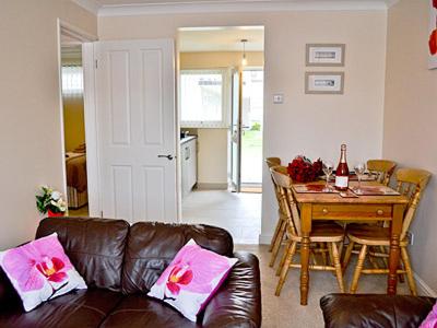 a living room with a leather couch and a table at Blue Waves in Perranporth