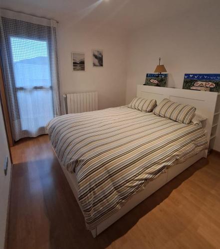 a bedroom with a large bed and a window at Casa los Rebecos in Villanúa