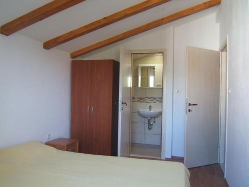 ein Schlafzimmer mit einem Bett und einem Waschbecken in der Unterkunft Apartments Emil in Murter