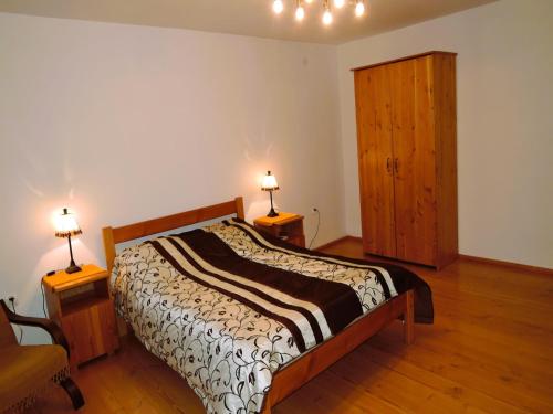 a bedroom with a bed and two lamps on two tables at Holiday Home Kolczewo near Baltic Sea Beach in Kołczewo
