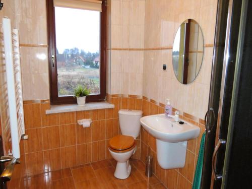 a bathroom with a toilet and a sink and a window at Holiday Home Kolczewo near Baltic Sea Beach in Kołczewo