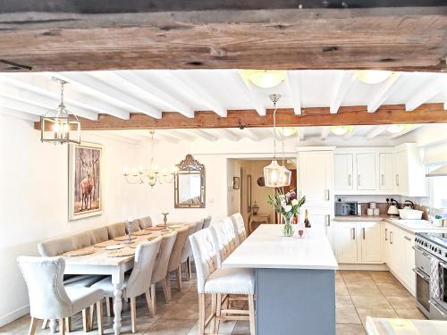 a kitchen with a long dining table and chairs at The Water Mill in Bradbourne
