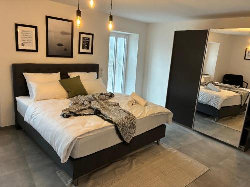 a bedroom with a large bed and a mirror at FeWo - EG Apartment Mosel- & Weinquartier, Terrasse, Parkplatz, moderne Küche bis 4 Personen in Piesport