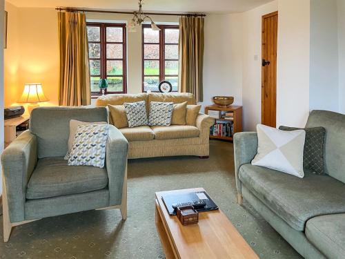 a living room with two couches and a table at Holly Bank in Crich
