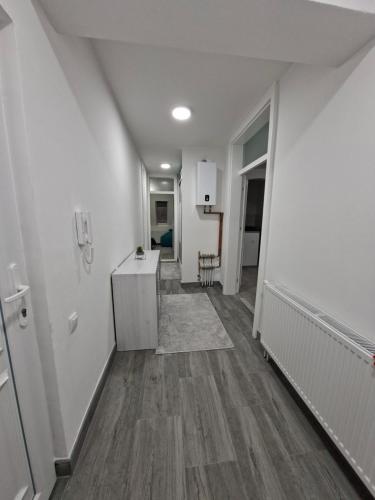 VlasenicaStan na dan Vlasenica的空的走廊,有白色的墙壁和木地板