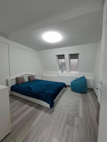 a bedroom with a bed and a blue blanket at Apartman Nikola in Vlasenica