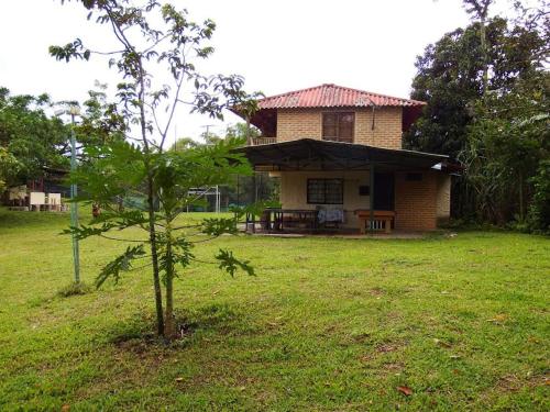 a small house in a field with a tree at Finca la Albania in Circasia