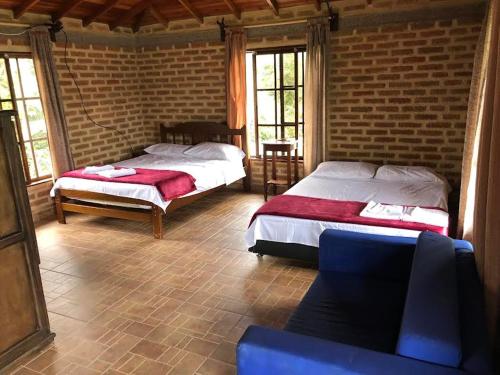 a bedroom with two beds and a couch and windows at Finca la Albania in Circasia