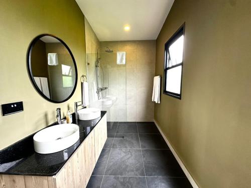 une salle de bain avec deux lavabos et un miroir dans l'établissement The Studio at Ziwa, à Baruti West