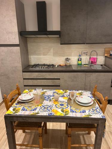 a kitchen with a table with plates and glasses on it at Casa Cristina2 in Grottaferrata