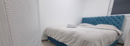 ヴァリェヴォにあるApartman A1-1のベッドルーム1室(青いヘッドボード付きのベッド1台付)