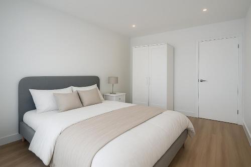 a white bedroom with a large bed with white walls at Euston, Russel Square, Kings Cross Designer's Stay in London