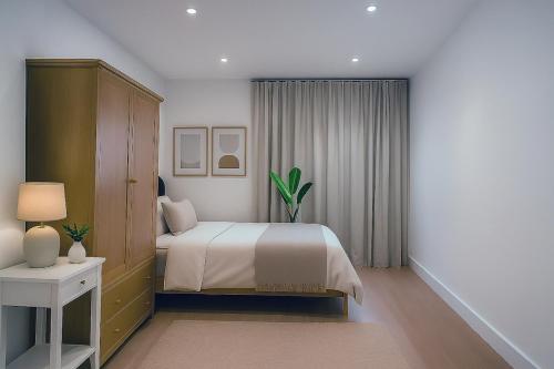 a bedroom with a bed and a table with a lamp at Euston, Russel Square, Kings Cross Designer's Stay in London