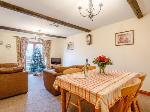 a living room with a table with flowers on it at Rafters Barn - E2064A in Runcton Holme