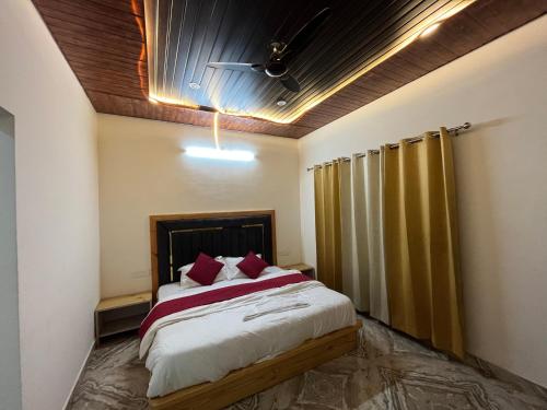 穆索里Rana farm house的卧室里有一张大床，配有红色枕头